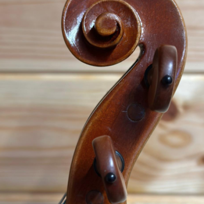 Parte superior do violino em madeira castanha com cravelhas