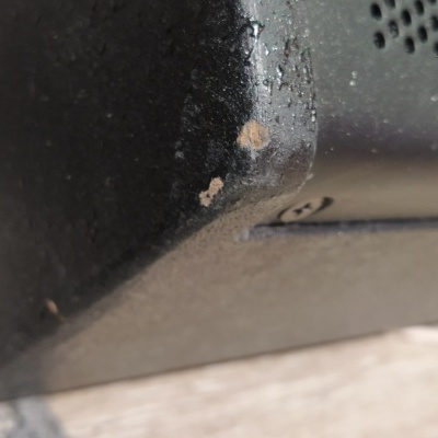 Canto desgastado de objeto preto texturizado sobre superfície clara