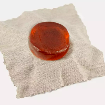 Sabonete âmbar redondo sobre tecido bege