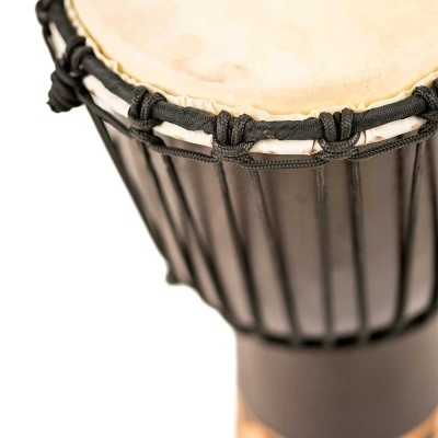 Tambor djembe com pele clara e cordas pretas, base em madeira com desenhos.