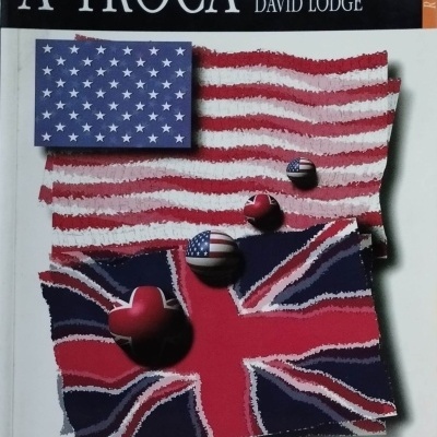 Capa de livro com título A TROCA e autor DAVID LODGE, mostrando bandeiras dos EUA e Reino Unido.
