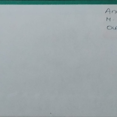 Folha branca com borda verde e papel colado com texto manuscrito no canto superior direito