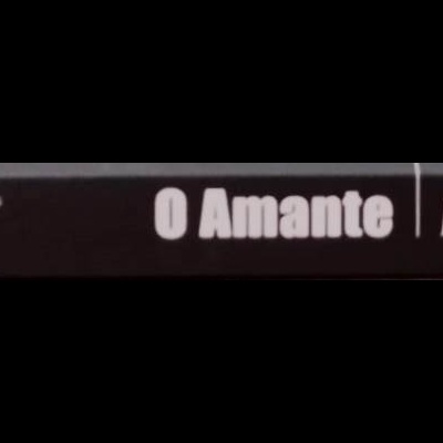 Lombada de livro preta com texto 'O Amante | MARGUERITE DURAS' e símbolo circular.