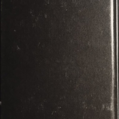 Livro de capa dura preta com marcas e desgaste