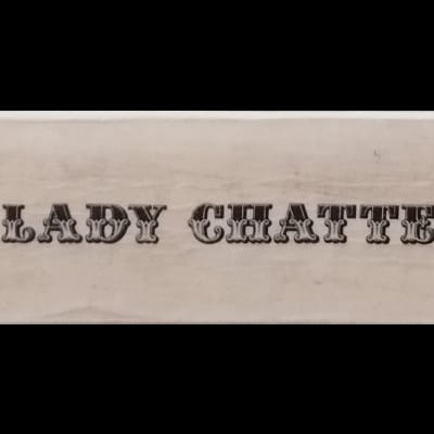 Lombada de livro bege com título 'O AMANTE DE LADY CHATTERLEY' e autor D.H. LAWRENCE em letras pretas