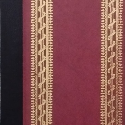 Livro com capa burgundy e decoração dourada na borda