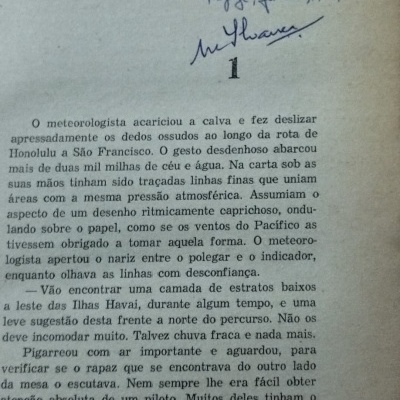Página amarelada de livro com texto em português e dedicatória manuscrita no topo