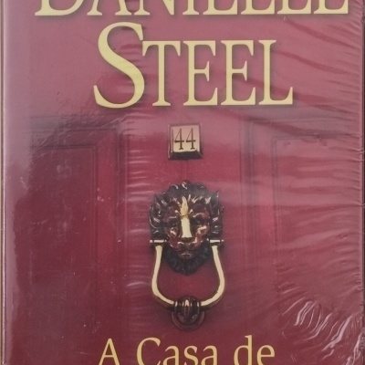 Capa de livro vermelha com texto Danielle Steel, A Casa de Charles Street e porta com maçaneta de leão