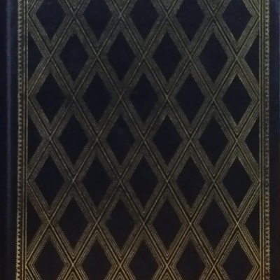 Livro capa dura preta com padrão dourado geométrico losangos