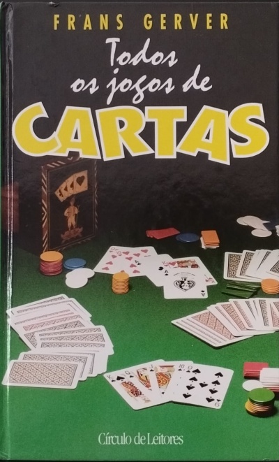 Livro com cartas e fichas de poker sobre mesa verde