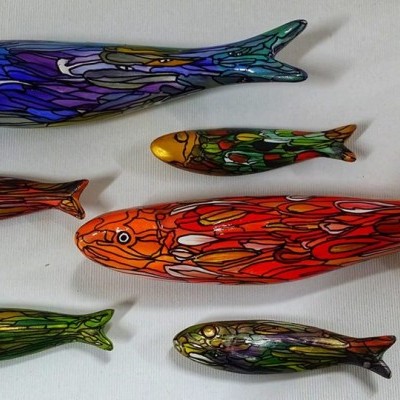 Seis esculturas coloridas de peixes em madeira com padrões vivos