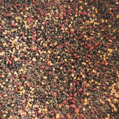 Mistura granular colorida em tons de preto, vermelho, amarelo e bege