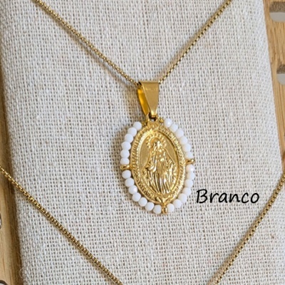 colar com pendente oval dourado com figura religiosa e contas brancas