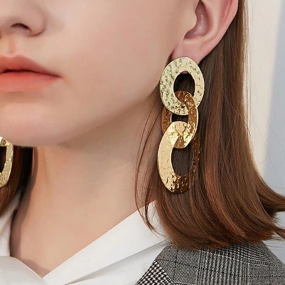 Brincos pendentes dourados com elos texturados