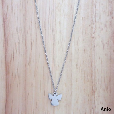 Colar prateado com pendente em forma de anjo sobre fundo de madeira clara