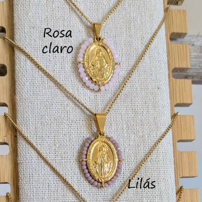 Colares dourados com pendentes ovais e contas rosa claro e lilás em tecido bege