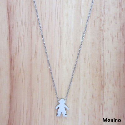 Colar prata com pendente de menino numa superfície de madeira clara