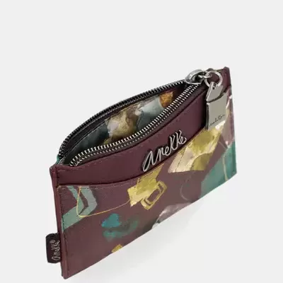 Carteira pequena com padrão abstrato em castanho, verde e amarelo e fecho metálico.