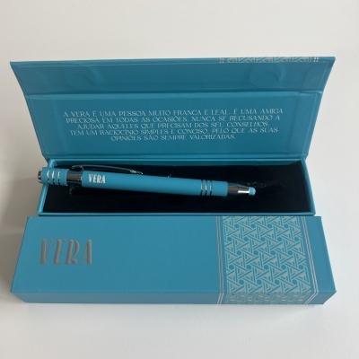Caneta azul dentro de caixa azul com texto e padrão geométrico