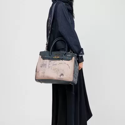 Mulher com casaco azul escuro e mala bege com detalhes pretos