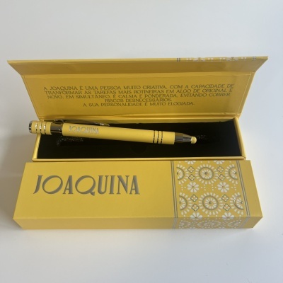 Caneta amarela com caixa amarela e texto explicativo no interior da tampa