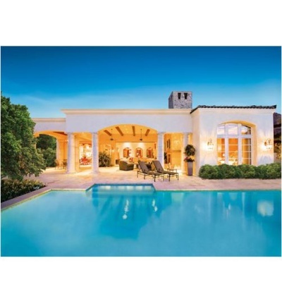 Casa mediterrânea branca com piscina azul e espreguiçadeiras na área exterior