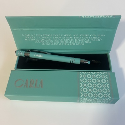 Caneta preta em estojo verde água com texto em português e padrão branco