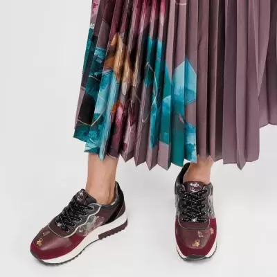 Tênis femininos bordô, preto e branco com detalhes dourados e saia plissada roxa e azul