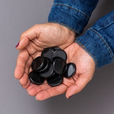 Mãos segurando discos pretos brilhantes, fundo cinzento