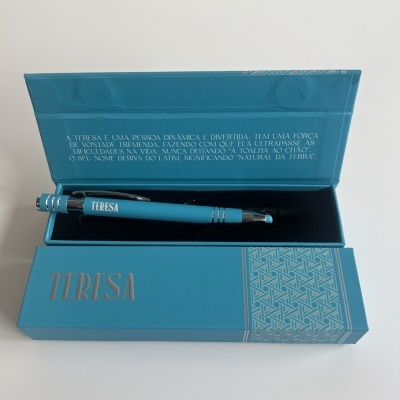 Caneta azul personalizada com nome Teresa numa caixa azul com texto motivacional em relevo