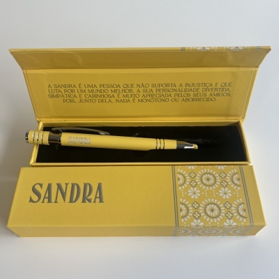 Conjunto de caneta amarela com detalhes pretos em caixa amarela com padrão decorativo