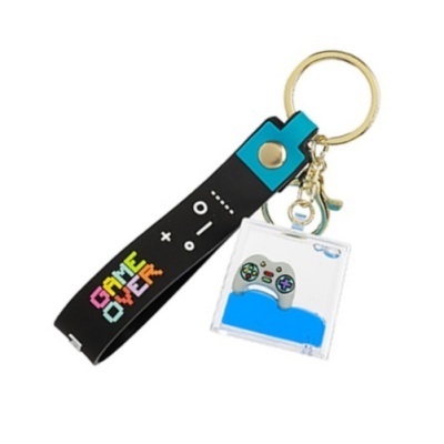 Chaveiro com fivela preta e azul com botão dourado e pendente com controlo de videojogos