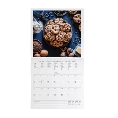 Calendário de parede aberto com imagem de biscoitos de chocolate e ingredientes para confeitaria.