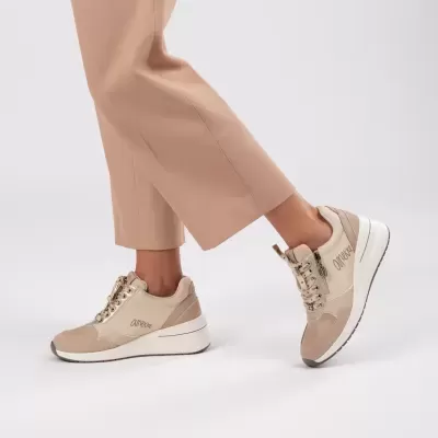 Ténis desportivos bege com sola branca grosso em fundo branco