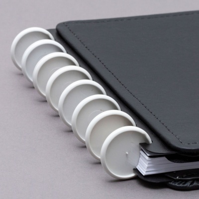 Caderno com capa preta em imitação couro e argolas brancas de plástico