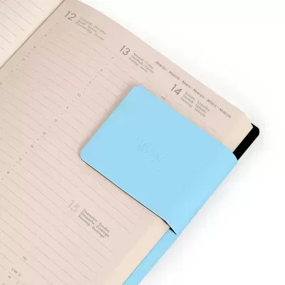 agenda aberta com marcador de página azul claro e texto 'Idea' em relevo