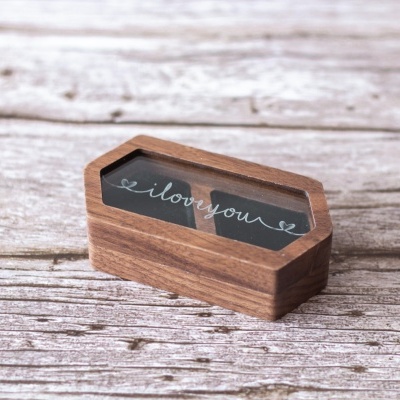 Caixa pequena de madeira com cartão preto com o texto 'i love you'