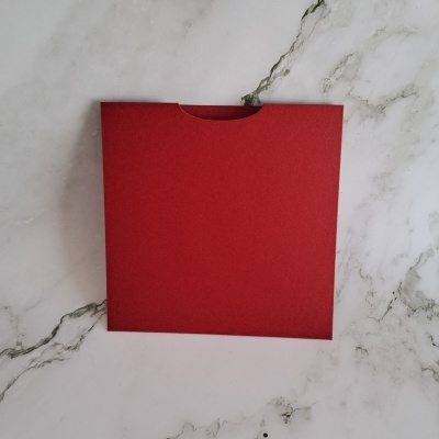 Envelope vermelho quadrado sobre mármore branco