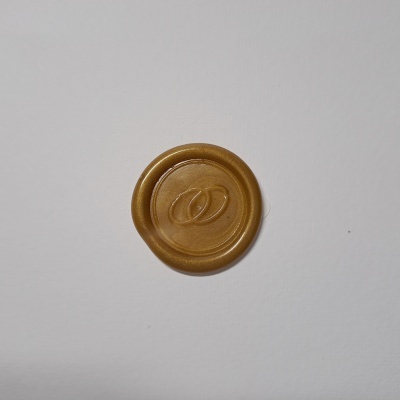 Selo de cera dourado com marca em relevo num fundo branco