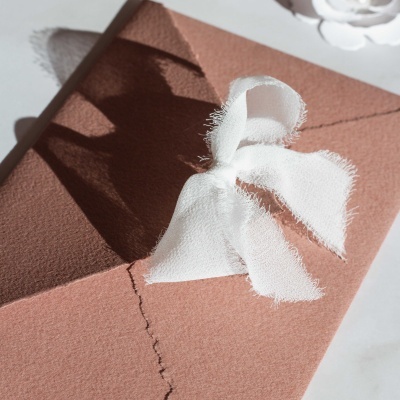 Envelope castanho claro com laço branco de tecido