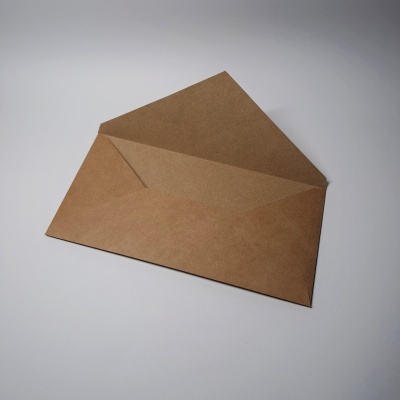 Envelope de papel castanho aberto sobre superfície branca