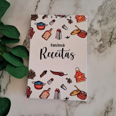 Livro de receitas com capa branca e desenhos coloridos de utensílios de cozinha