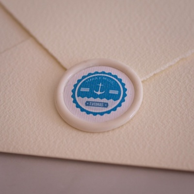 Envelope creme com selo branco e etiqueta azul com âncora