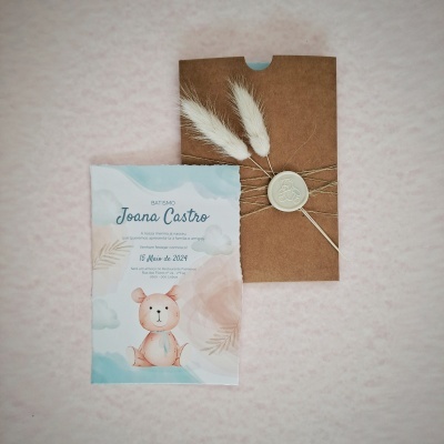 Convite de batismo com ilustração de urso e envelope castanho com selo de cera e flores secas