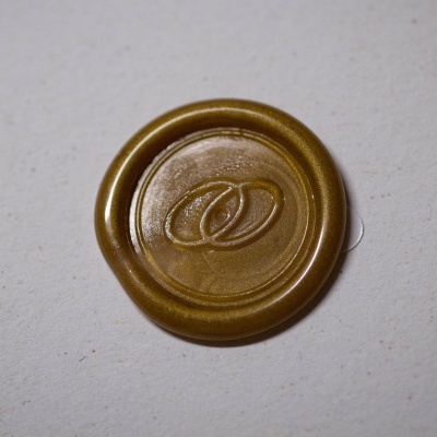 Selo de cera dourada circular com dois anéis entrelaçados