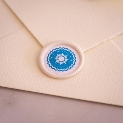 Envelope creme texturizado com selo redondo branco e azul