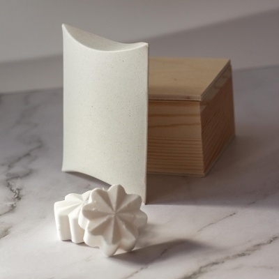 Conjunto de sabonete branco e caixa de madeira sobre mármore