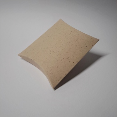 Caixa de papel kraft bege em forma de almofada sobre fundo branco