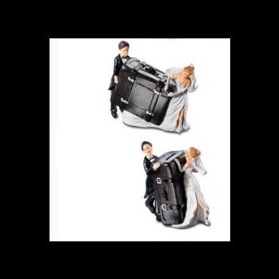 Figuras de bolo noivo e noiva segurando mala preta