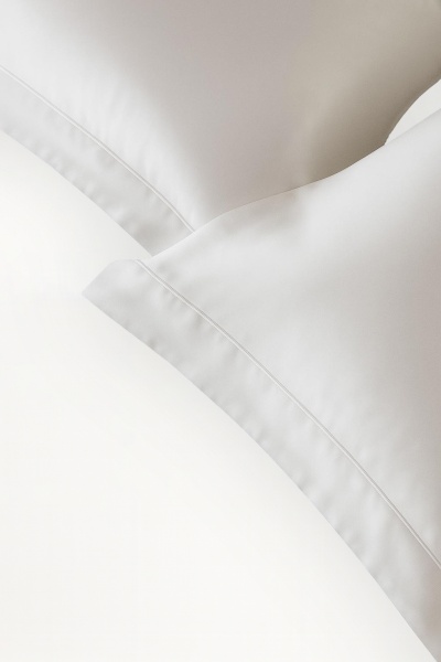 Roupas de cama brancas, almofadas e lençol com vinco simples